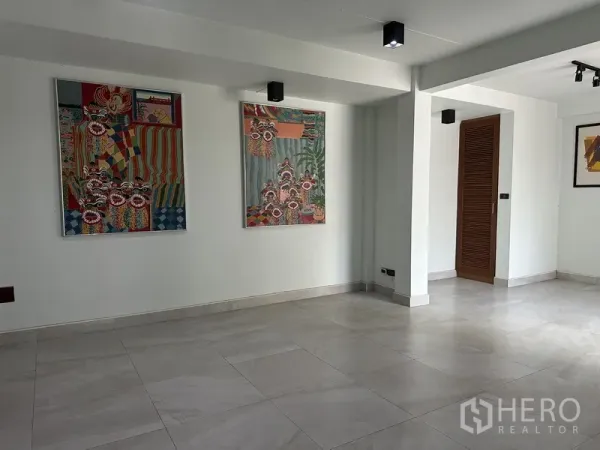 Home Office for rent in Watthana, Bangkok - Bright ground-floor room with large tiled floor and colorful wall art.