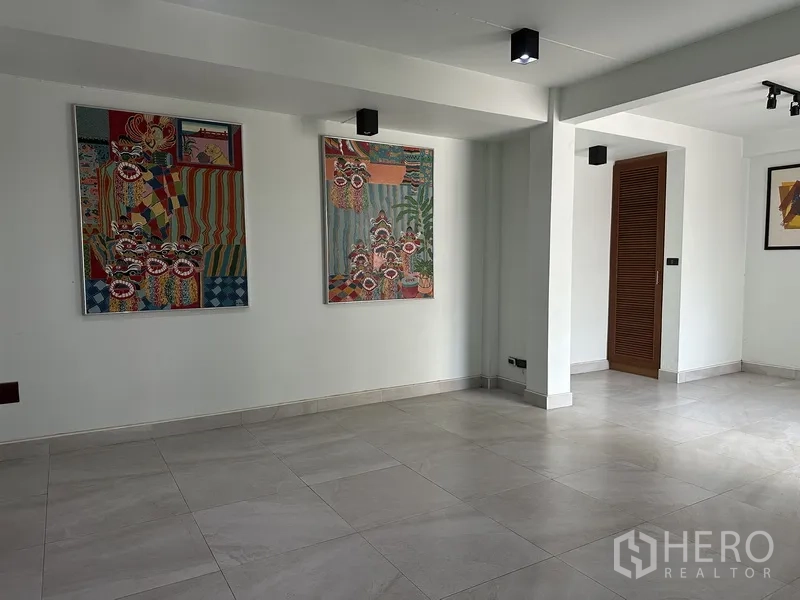 Home Office for rent in Watthana, Bangkok - Bright ground-floor room with large tiled floor and colorful wall art.