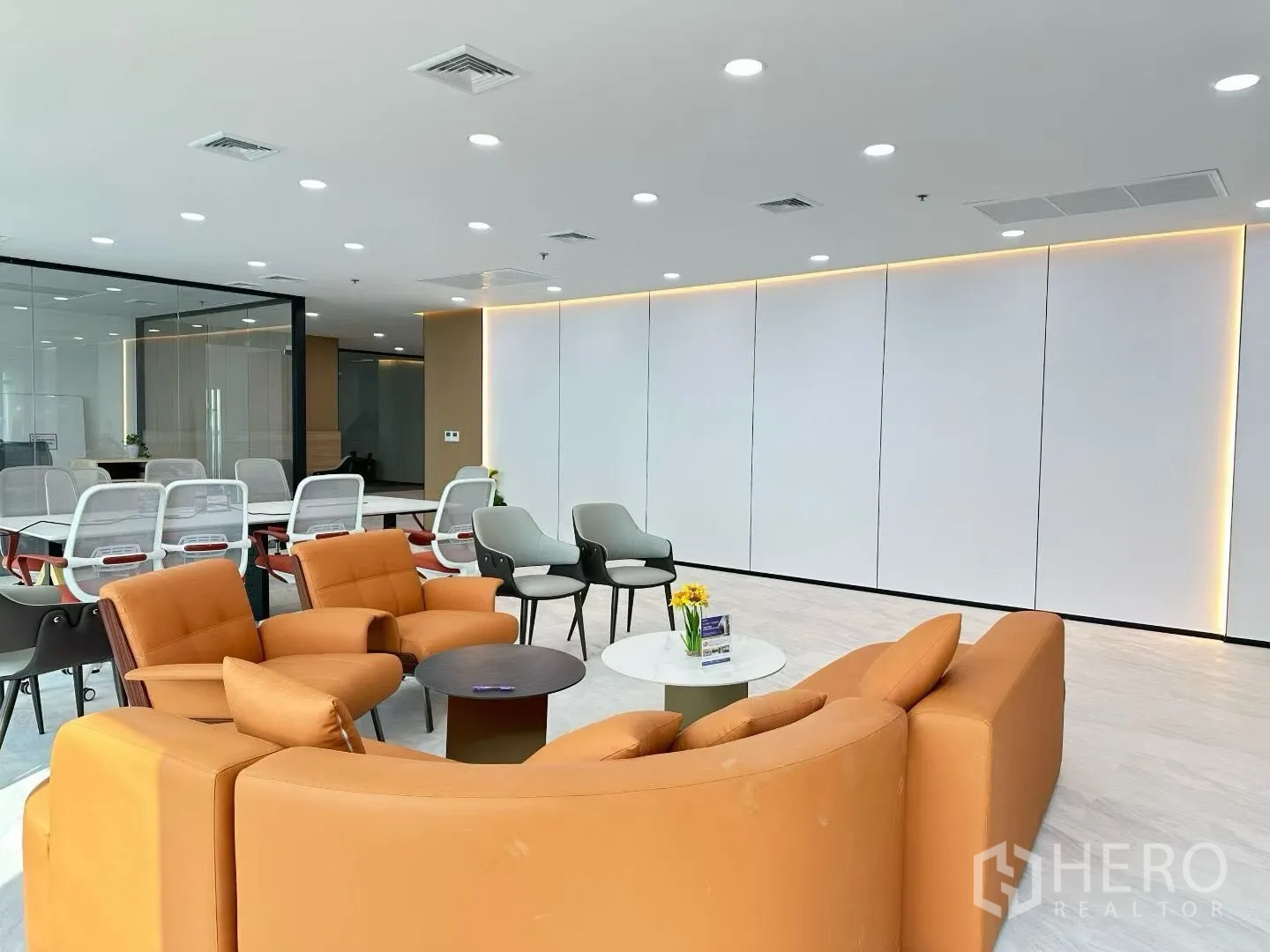办公空间 for rent in Huai Khwang, Bangkok - 舒适休闲座位，正对玻璃会议室，暖色筒灯营造氛围。