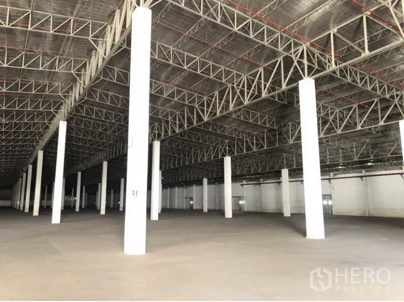 Warehouse for rent in Lam Luk Ka, Pathum Thani - Open-plan warehouse interior showing insulated roof, sprinkler lines, and evenly spaced columns.