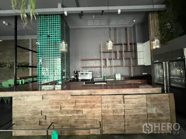 Retail Space for rent - Wood-clad service bar with green tile column, shelving and coffee machine.