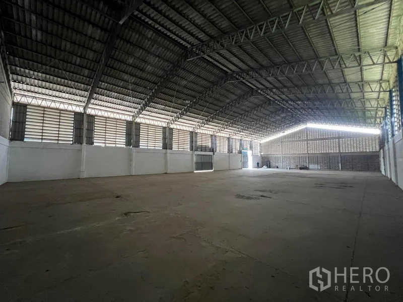 Warehouse for rent in Bang Pa-in, Phra Nakhon Si Ayutthaya - Open storage hall with steel trusses, ventilated walls and solid concrete flooring.