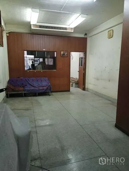 店屋 出租在Khlong Toei, Bangkok - 简洁房间，木质隔断、日光灯和盖布沙发。