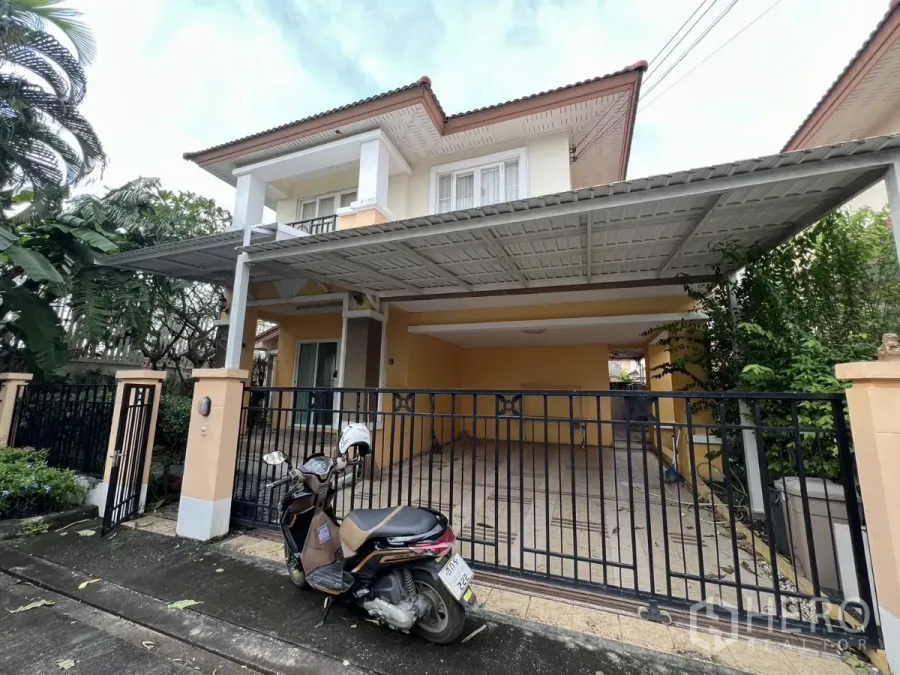 Detached House for rent in Bang Kapi, Bangkok - Detached house exterior with gated entrance and covered carport surrounded by greenery.