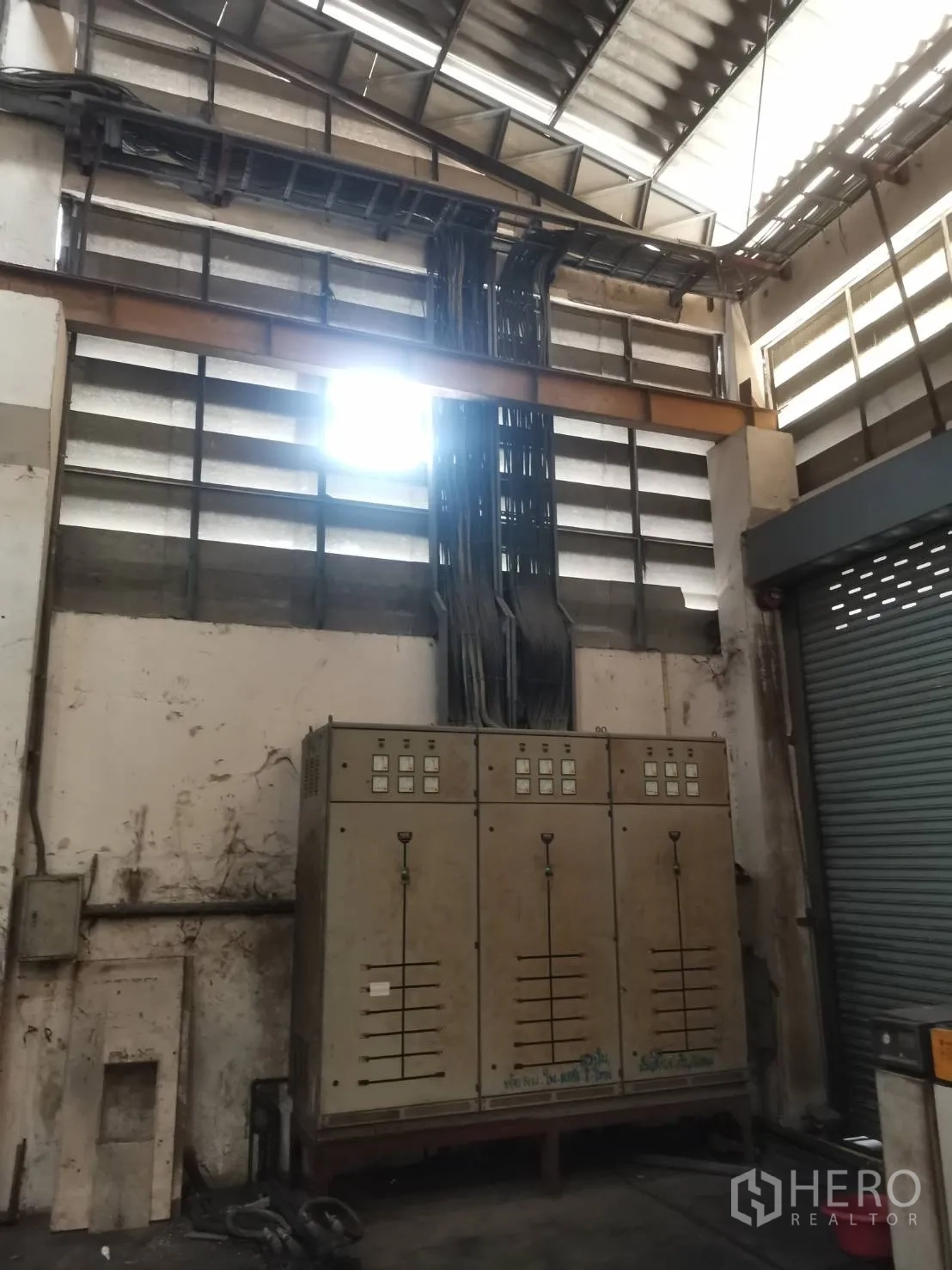 Factory for rent or sale in Bang Khun Thian, Bangkok - Electrical cabinets beneath cable trays and louvered wall for ventilation.