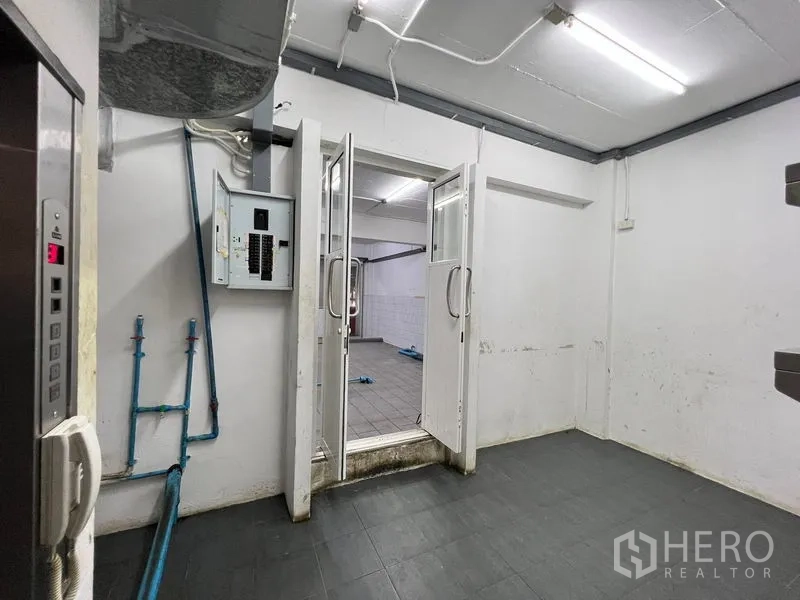 Shophouse for rent - Service room with double doors, electrical panel and access to the kitchen.