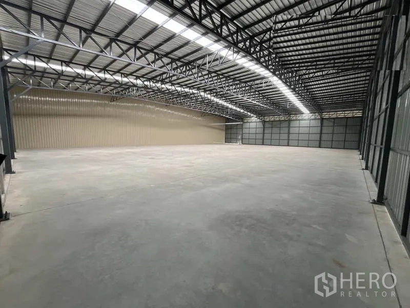 Warehouse for rent or sale in Pak Kret, Nonthaburi - Column-free storage hall with metal cladding walls and long roof lights for natural illumination.