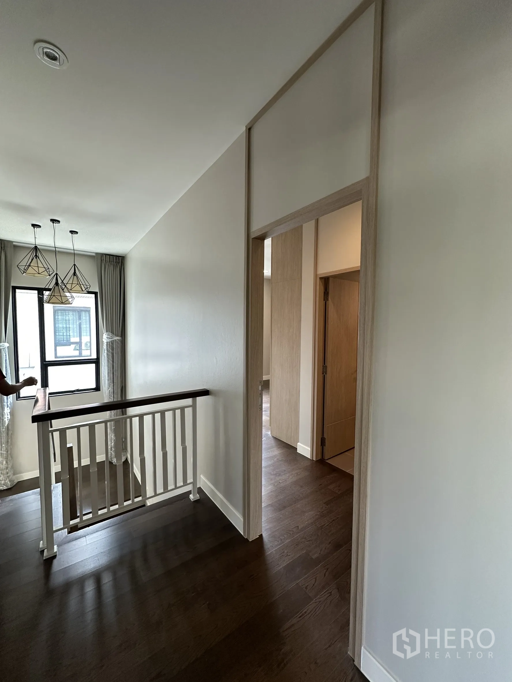 Detached House for sale in Lam Luk Ka, Pathum Thani - Stair landing with modern pendant lights and wooden handrail.