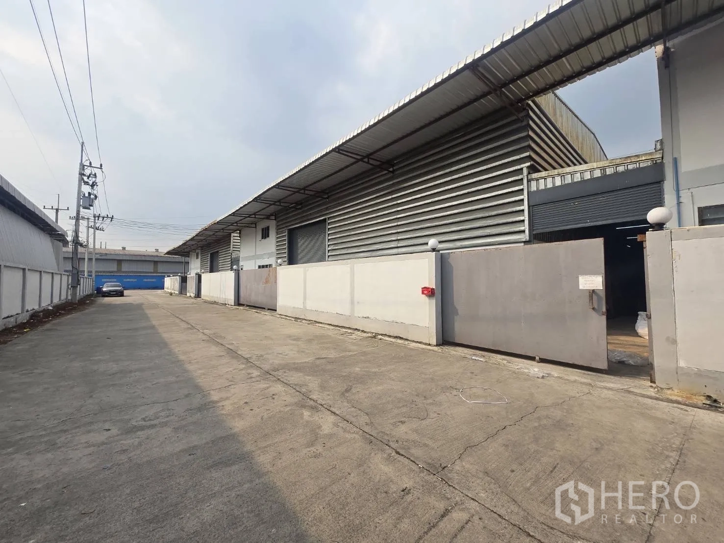 Factory for rent or sale in Mueang Samut Sakhon, Samut Sakhon - Private access road within the industrial compound lined with factory units and secure gates.