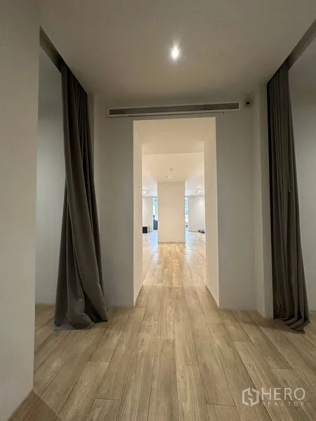 Home Office for rent in Phra Khanong, Bangkok - Simple hallway with white doors and wood-look floor.