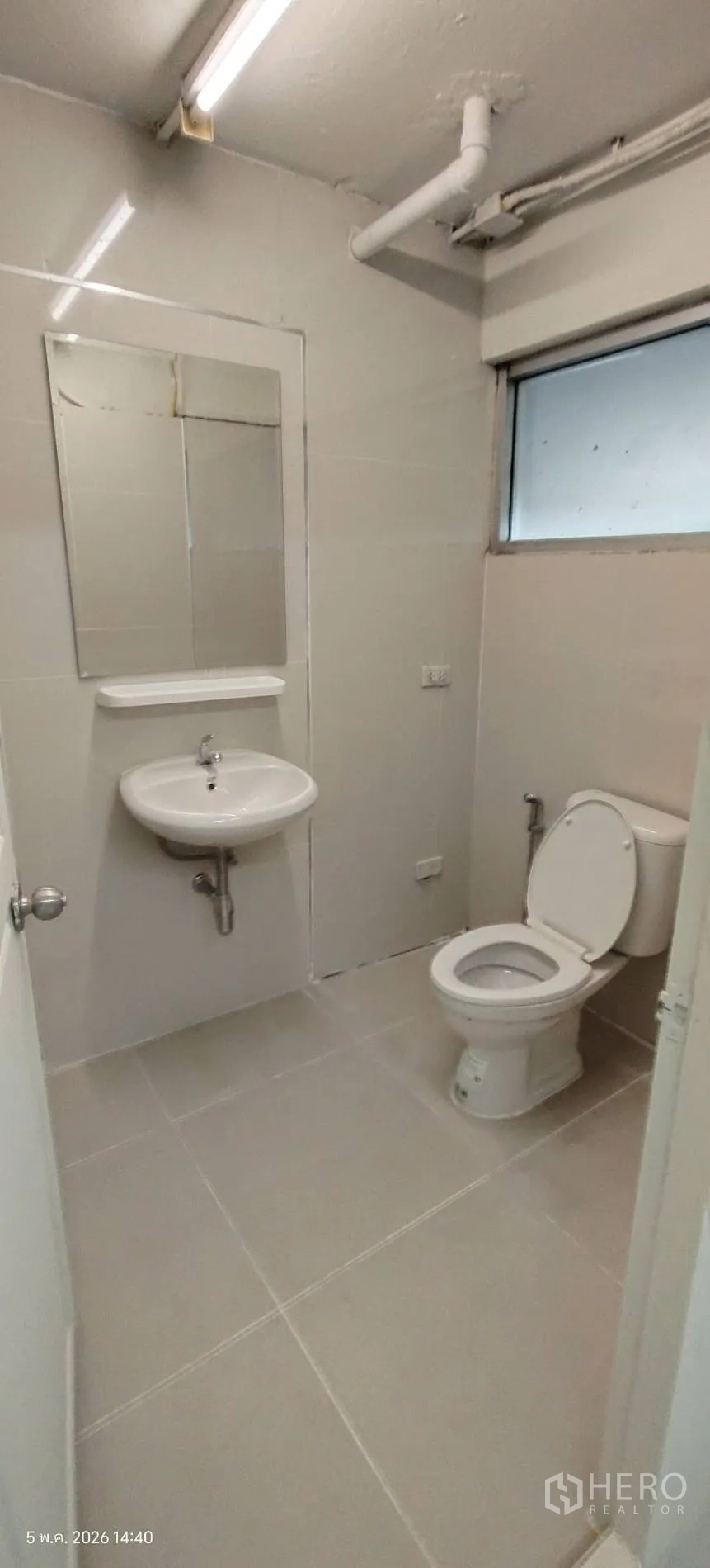 Shophouse for rent in Watthana, Bangkok - Simple room with barred windows and a table.