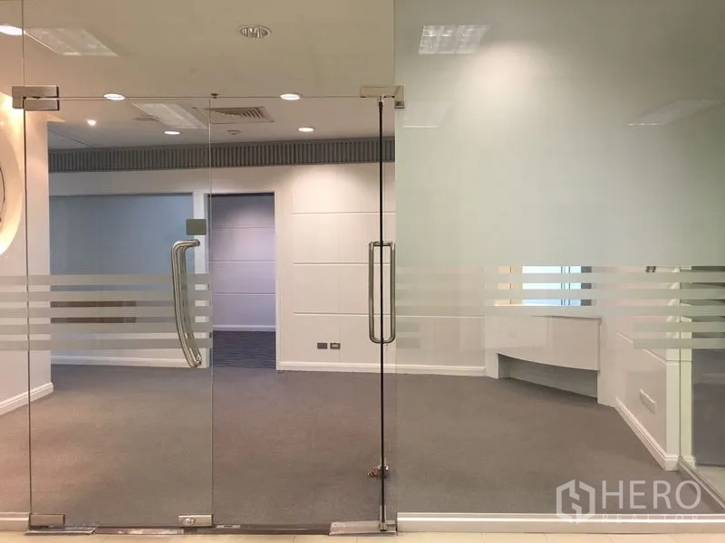 Office Space for rent in Chatuchak, Bangkok - Entrance with double glass doors featuring frosted stripes leading to a carpeted workspace.