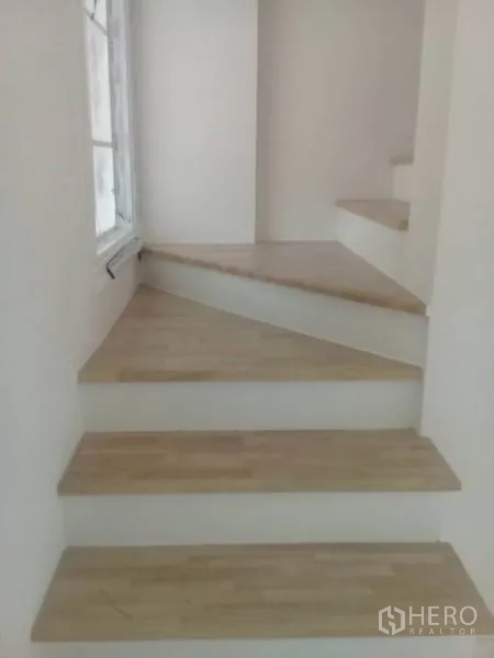 Home Office for rent in Bang Na, Bangkok - Light-wood staircase with a side window bringing natural light to the landing.