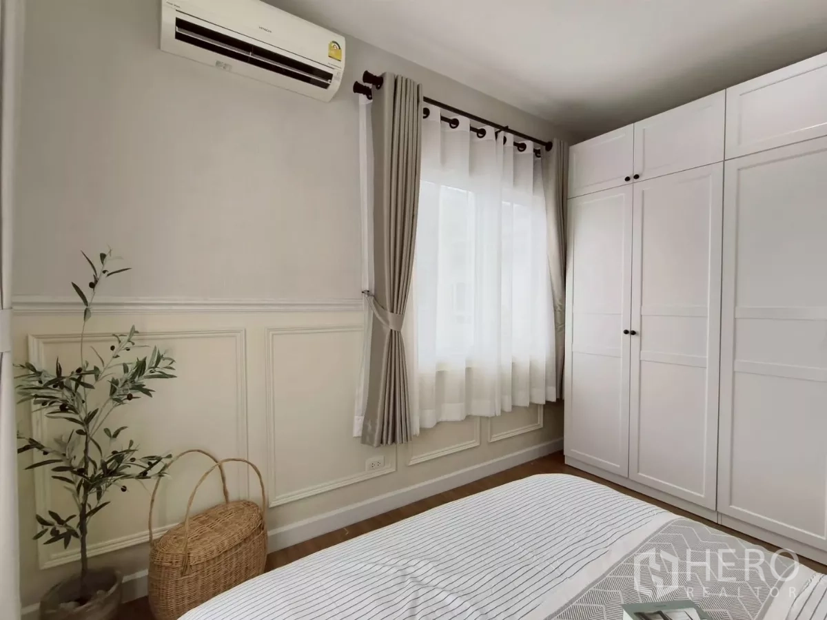 Detached House for rent in Khlong Luang, Pathum Thani - Bedroom corner with white wardrobe, curtains and potted plant