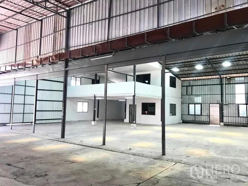 货栈 出租在Pathum Thani - 宽大的存储大厅，中央办公室核心，侧边推拉门与混凝土地面。