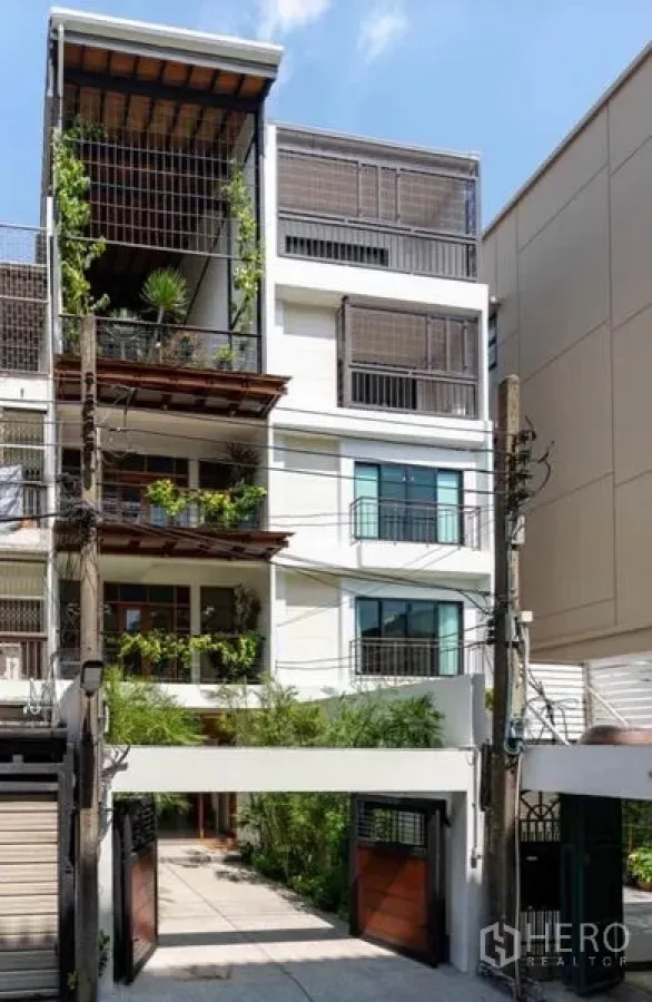 联排别墅 出租在Pathum Wan, Bangkok - Nana瓦他那多层联排别墅外观，带绿植与电动门停车位
