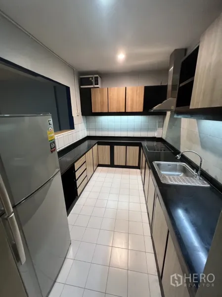 Townhouse for rent in Watthana, Bangkok - Bright kitchen view with fridge, sink and generous countertop space.