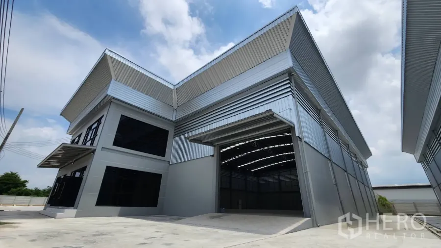 Factory for rent or sale in Bang Bo, Samut Prakan - Modern factory exterior with high roller shutter, wide loading apron and metal cladding in Bang Bo, Samut Prakan.