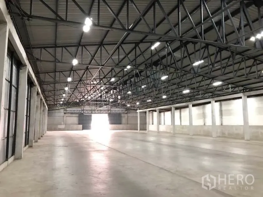 Warehouse for rent in Pak Kret, Nonthaburi - Spacious renovated warehouse interior with high steel truss roof, bright LED lighting and polished concrete floor in Pak Kret.