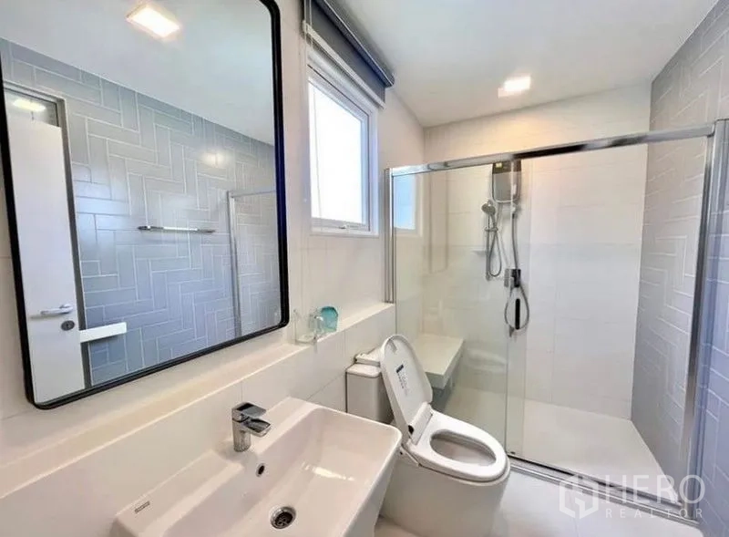 Detached House for rent - Modern bathroom with large mirror, glass-enclosed shower and white sanitary ware.