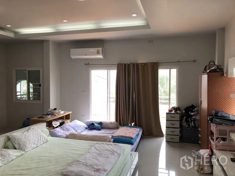 Detached House for sale in Lam Luk Ka, Pathum Thani - Oversized bedroom with sliding doors to a balcony and floor mattresses.