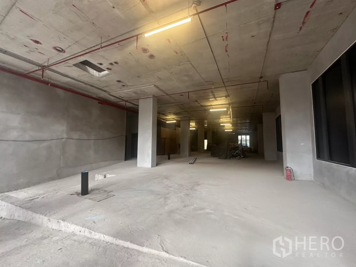 Retail Space for rent in Watthana, Bangkok - Deep interior of the retail space showing columns, exposed ceiling and sprinkler lines.