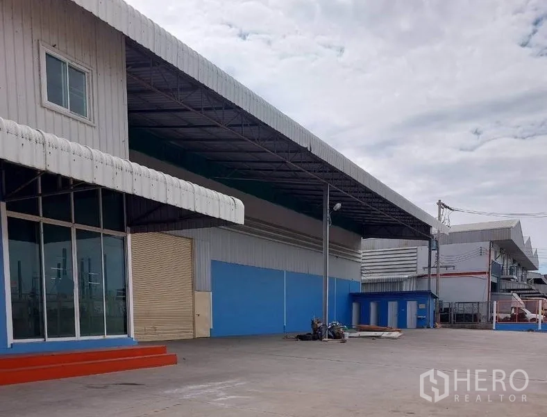 Factory for rent in Lat Lum Kaeo, Pathum Thani - Covered loading bay with roller shutter doors and open yard at the factory.