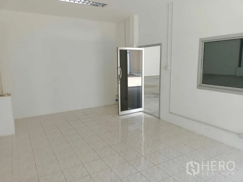 Warehouse for rent in Suan Luang, Bangkok - Bright office room with tiled floor, glass door to the warehouse, and sliding window.