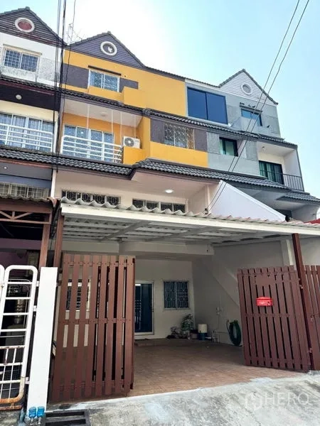 Townhouse for rent or sale in Suan Luang, Bangkok - Multi-level townhouse facade with covered carport and brown gate in Suan Luang