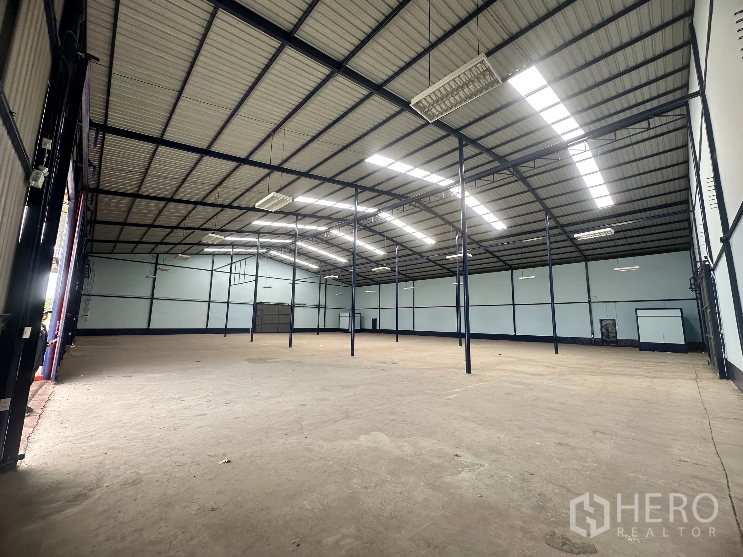 Warehouse for rent in Lat Krabang, Bangkok - Interior view toward an open loading bay with tall shutter doors and a concrete slab.