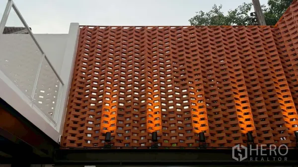 带办公室的家 出租在Watthana, Bangkok - 素坤逸出租家庭办公的红陶通风墙立面与暖色壁灯。