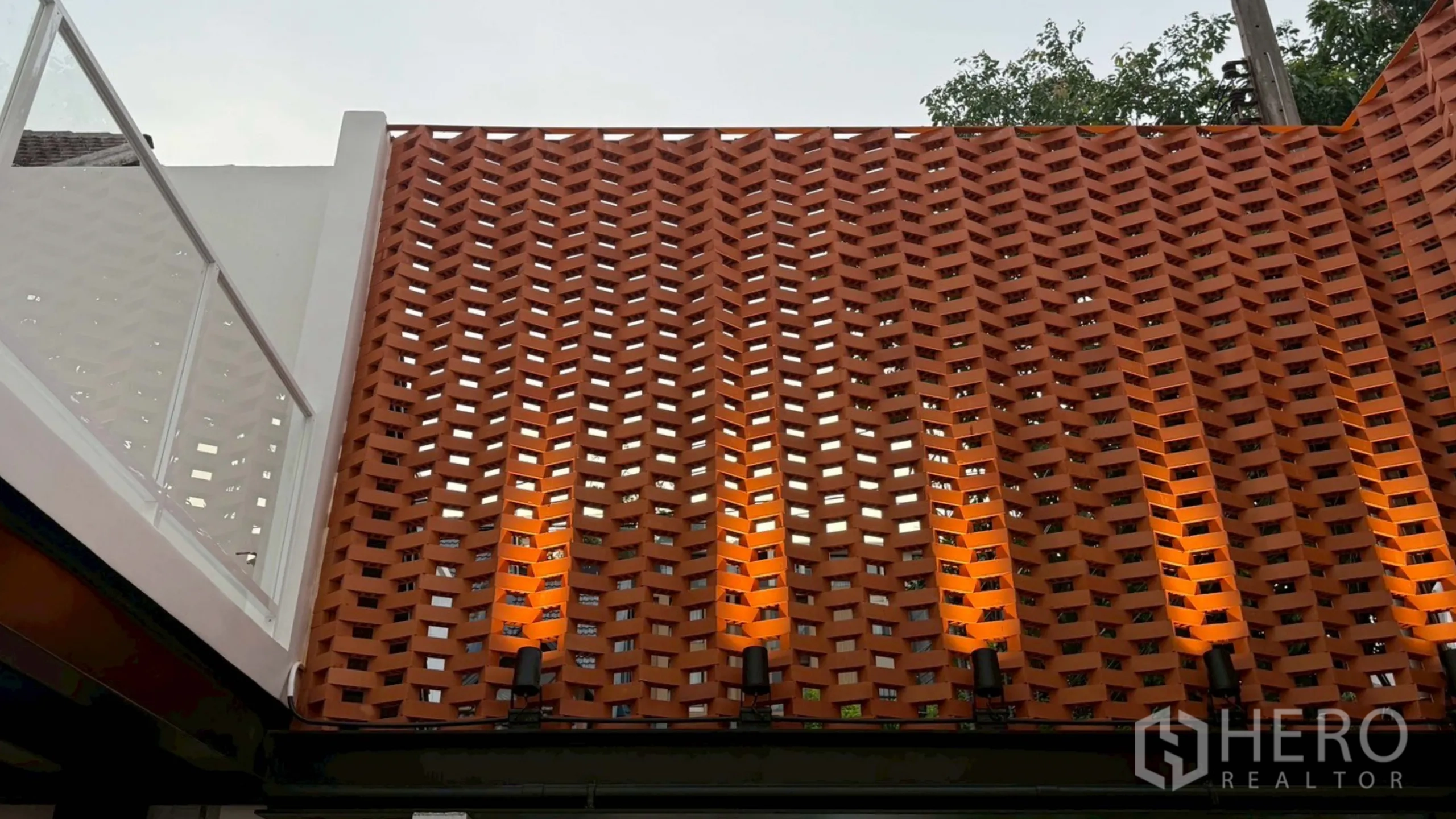 带办公室的家 出租在Watthana, Bangkok - 素坤逸出租家庭办公的红陶通风墙立面与暖色壁灯。
