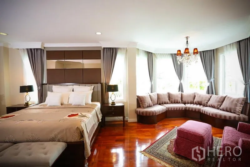 Detached House for rent in Bang Na, Bangkok - Expansive master suite with corner sofa, chandelier and multiple picture windows.