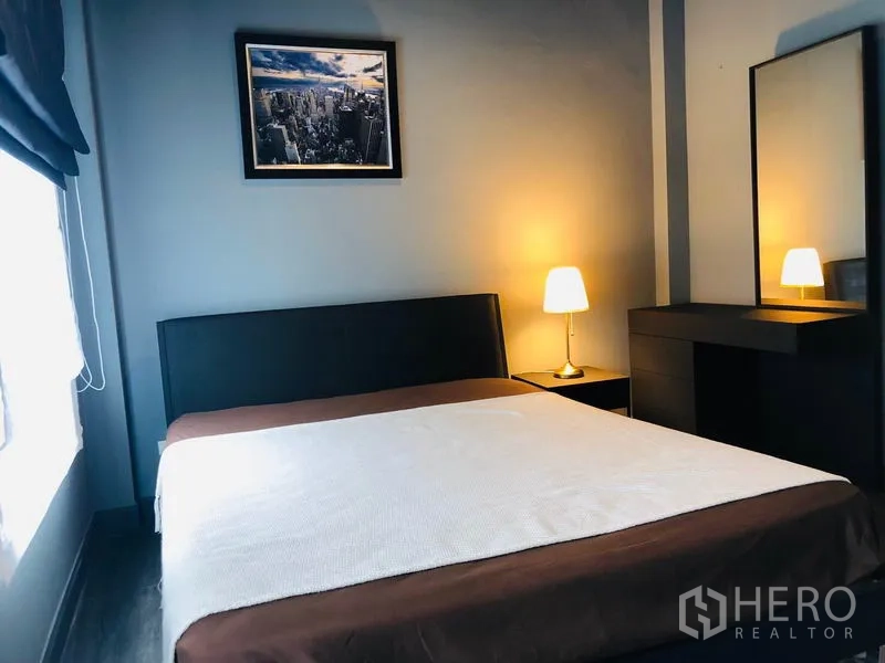 Townhouse for rent in Bang Kapi, Bangkok - Bright bedroom with double bed, bedside lamps and a dressing table with mirror.