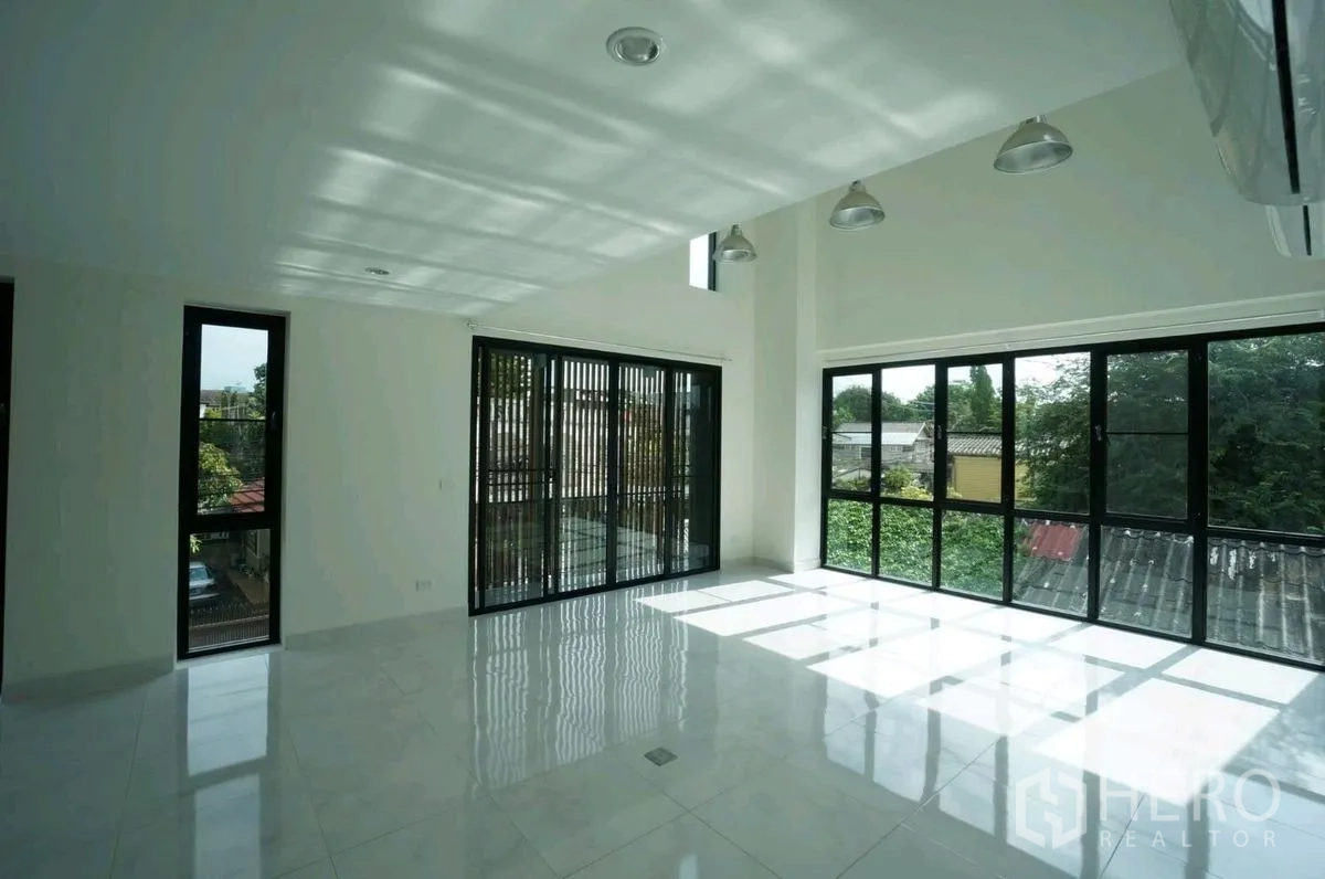 Home Office for rent in Chatuchak, Bangkok - Sunlit open-plan room with glossy tile floors and sliding glass doors.