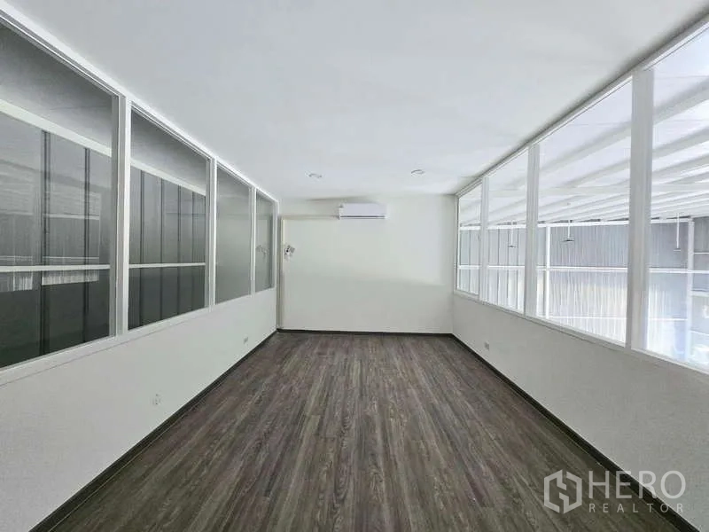 Warehouse for rent in Wang Thonglang, Bangkok - Bright mezzanine office with windows on two sides and wood-look flooring.