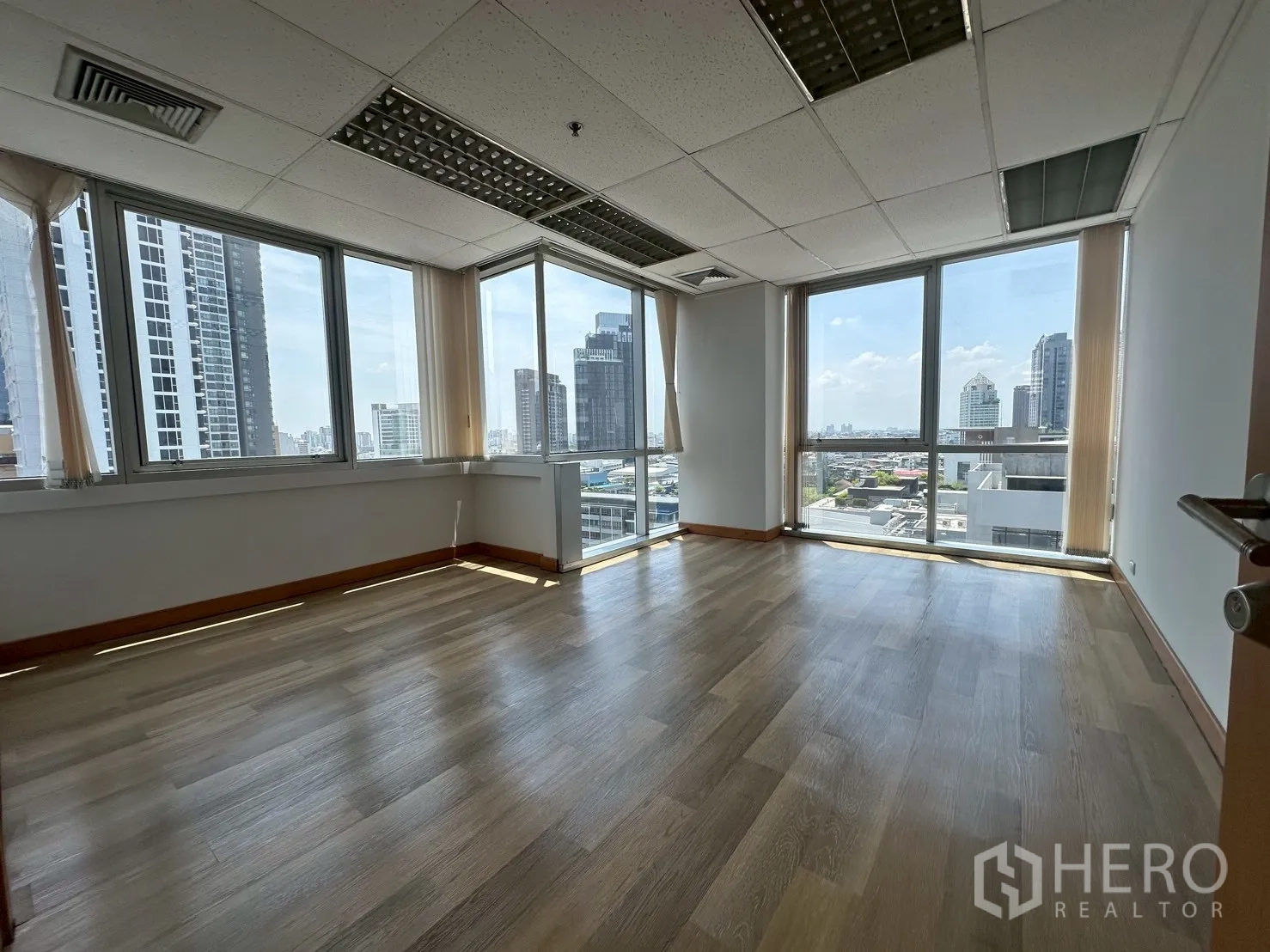 Office Space for rent - Corner office with panoramic city views through floor-to-ceiling style windows.