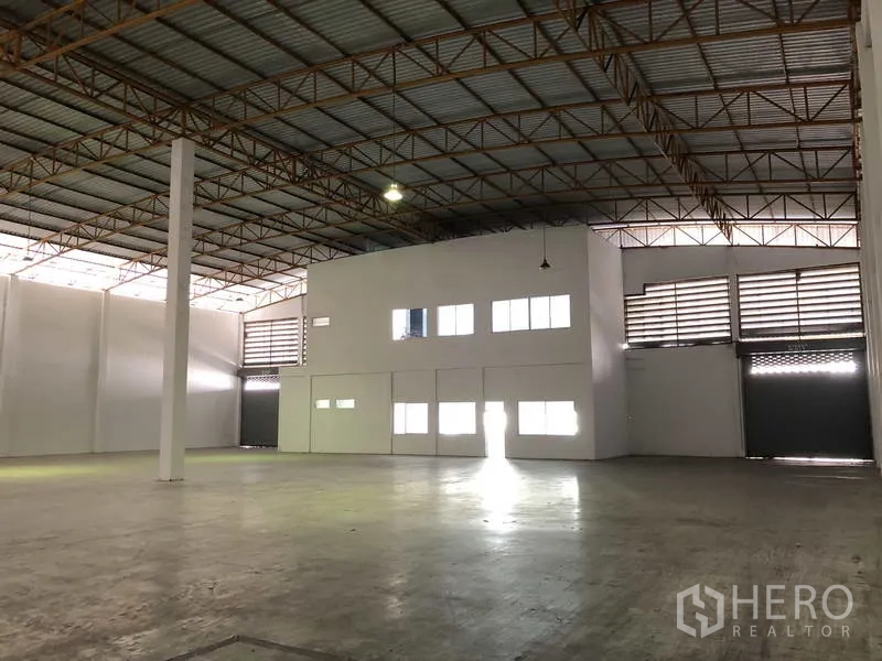 Warehouse for rent in Phra Nakhon Si Ayutthaya - Warehouse hall showing internal office box, roller shutter loading doors and clear span floor.