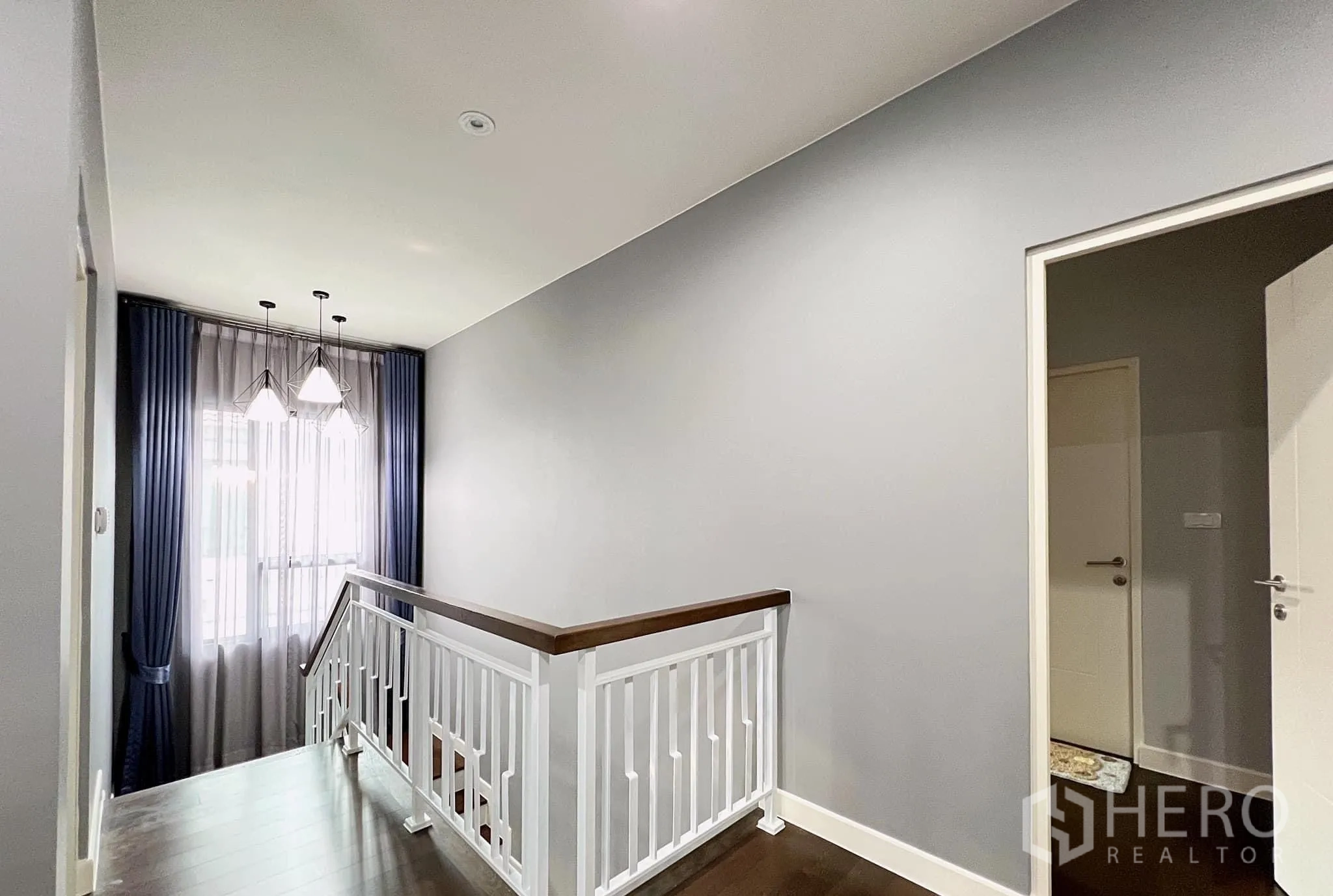 Detached House for rent or sale in Lam Luk Ka, Pathum Thani - Upper landing with white railing and doorway to bedrooms.