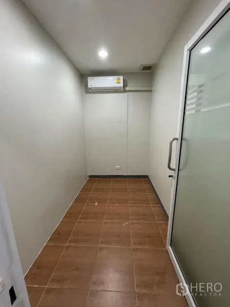 Home Office for rent in Chatuchak, Bangkok - Narrow meeting or storage room with frosted glass door and air conditioner.