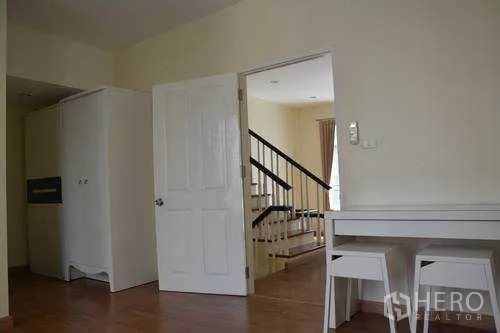 Home Office for rent in Wang Thonglang, Bangkok - Multi-purpose room with desk set, white door and view to stair landing inside a Wang Thonglang home office.