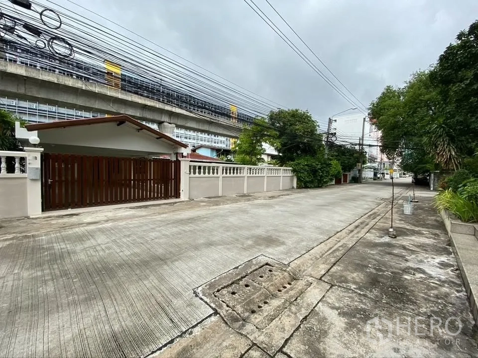 独栋房屋 for rent in Suan Luang, Bangkok - 安静住宅街景，可见房屋前门与围墙。