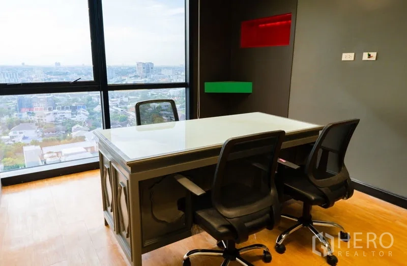 Office Space for rent - Private office with panoramic city view, dark feature wall and two guest chairs.