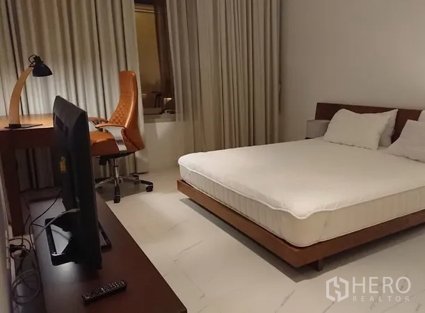 Condominium for rent in Pathum Wan, Bangkok - Bedroom with work desk, TV console, full-length curtains and a platform bed for a quiet study and rest area.