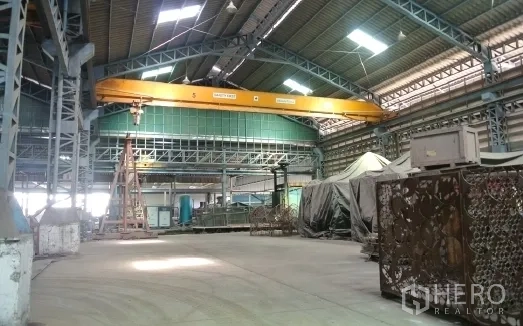 Factory for sale in Bang Phli, Samut Prakan - Factory bay with overhead crane and heavy equipment.