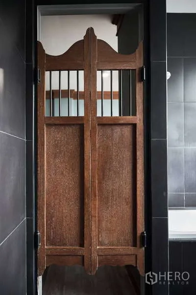 Townhouse for rent in Khlong Toei, Bangkok - Swinging wooden saloon doors leading into black‑tiled room