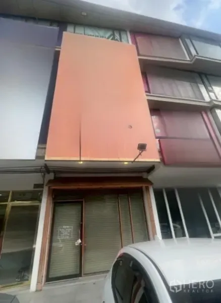 Shophouse for rent - Multi-storey shophouse exterior with orange facade, upper glass windows, and a ground-floor roller shutter near On Nut.