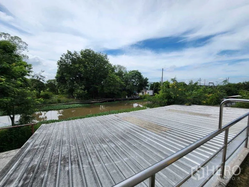 Warehouse for rent in Lat Krabang, Bangkok - Rooftop metal deck overlooking a canal and greenery.