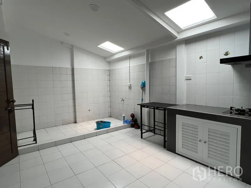 Townhouse for rent in Din Daeng, Bangkok - Utility and wet kitchen zone with tiled floor, raised laundry platform and skylights.