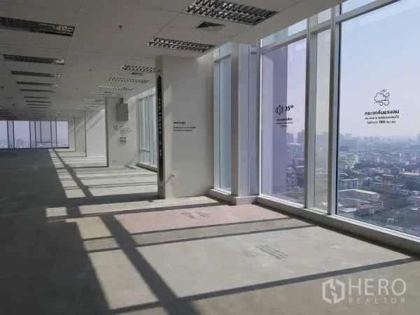 Office Space for rent - Large corner office floor in bare-shell condition with ceiling grid and panoramic floor-to-ceiling windows.